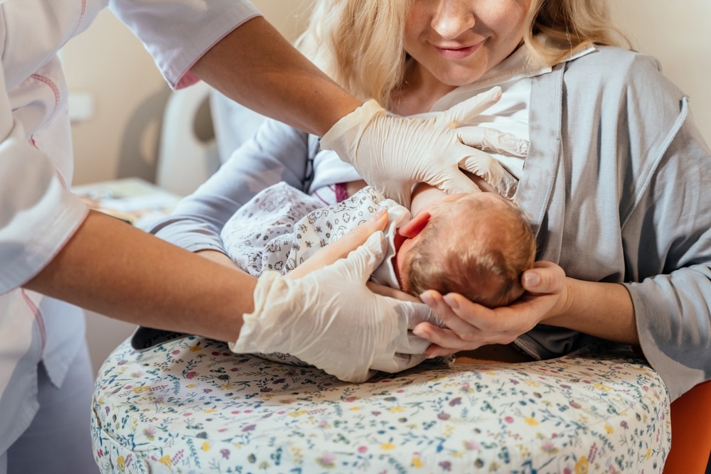 Woman holds her newborn baby after OB-GYNs helped her through a high-risk pregnancy.